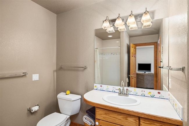 Bathroom with vanity, tiled shower, and a textured wall | Image 23