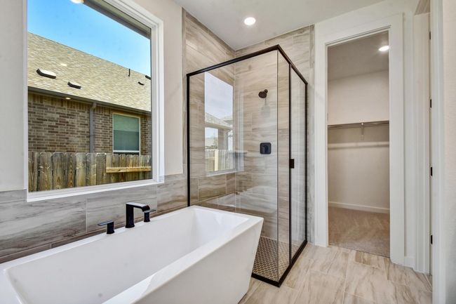 Bathroom featuring a freestanding bath, a shower stall, a walk in closet, and recessed lighting | Image 16