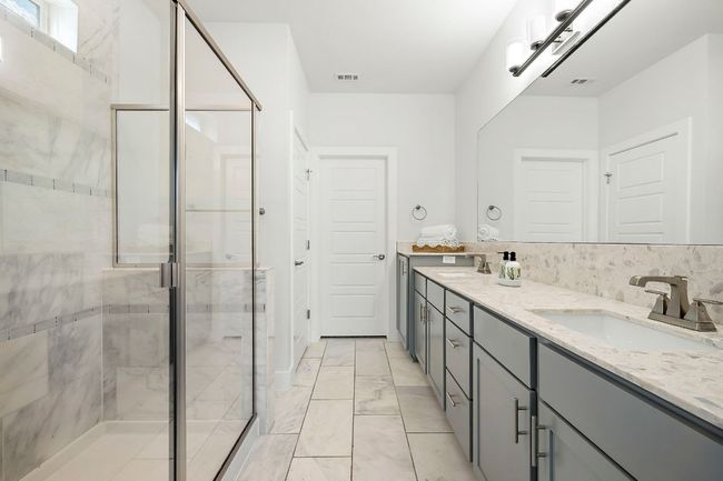 Bathroom with double vanity, marble finish floor, a sink, visible vents, and a stall shower | Image 20