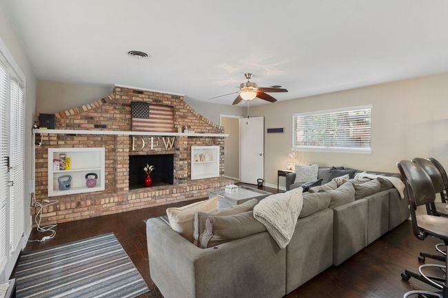 Living area featuring ceiling fan, hardwood / wood-style floors, a fireplace, and baseboards | Image 8