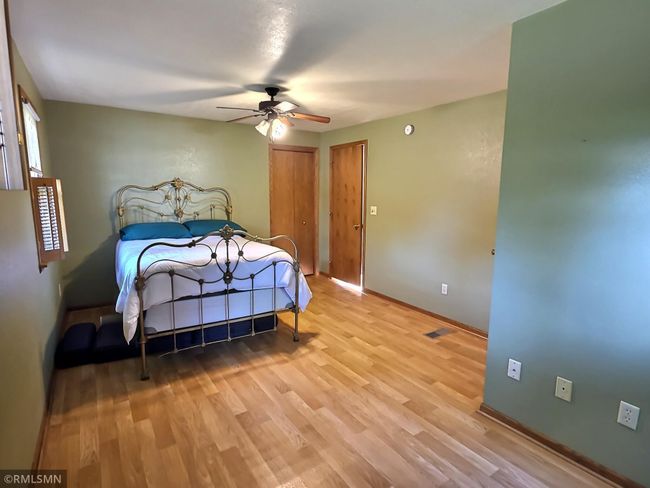 The main level bedroom is extremely spacious in size while offering a walk-in closet and separate access to the bathroom. The linoleum floors continue through to the living space. | Image 11