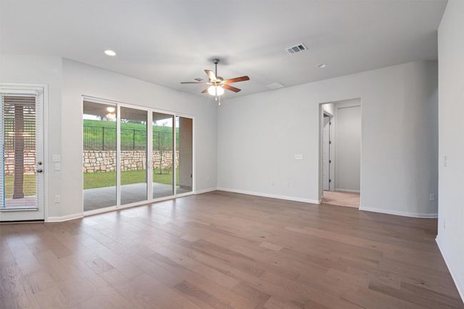 Unfurnished room with a ceiling fan, visible vents, baseboards, and wood finished floors | Image 10