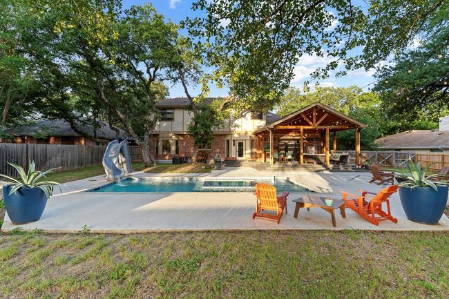 View of pool featuring a water slide, a fenced backyard, and a patio area | Image 37