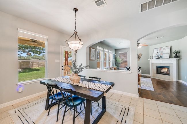 Tiled dining area featuring ceiling fan, arched walkways, and a tiled fireplace | Image 9