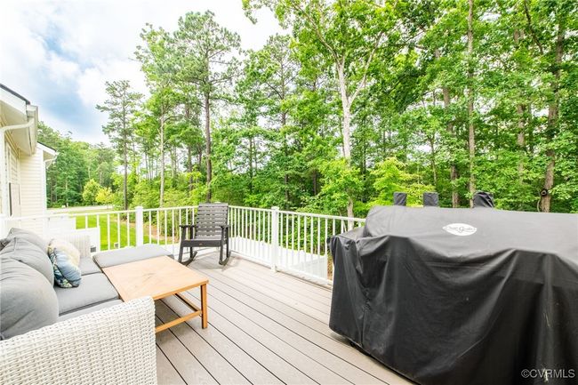 Wooden deck featuring area for grilling, view of wooded area, and an outdoor living space | Image 16