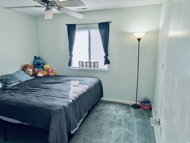 Bedroom with a textured ceiling, carpet floors, and ceiling fan | Image 13
