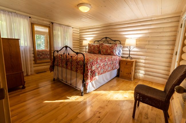 Bedroom with rustic walls, light hardwood / wood-style floors, and wood ceiling | Image 30