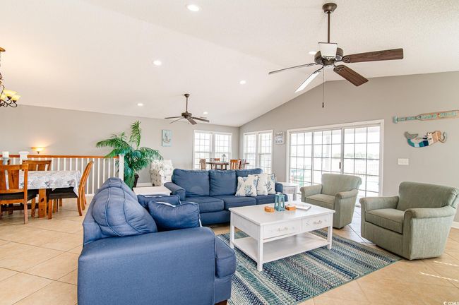 Living room featuring a ceiling fan, light tile patterned floors, recessed lighting, lofted ceiling, and a chandelier | Image 25