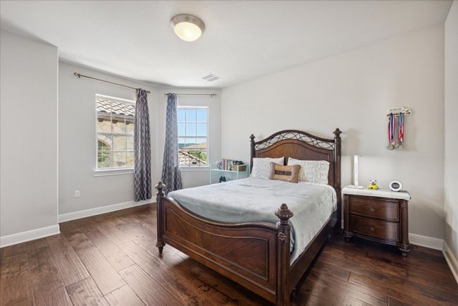 Bedroom featuring dark wood-style floors, baseboards, and visible vents | Image 26