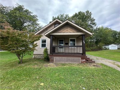 Bungalow featuring a shed, covered porch, and a front yard | Image 2