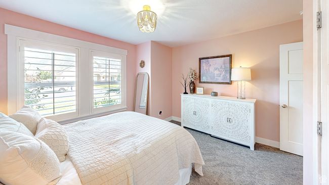 Bedroom featuring baseboards, an inviting chandelier, and carpet | Image 20