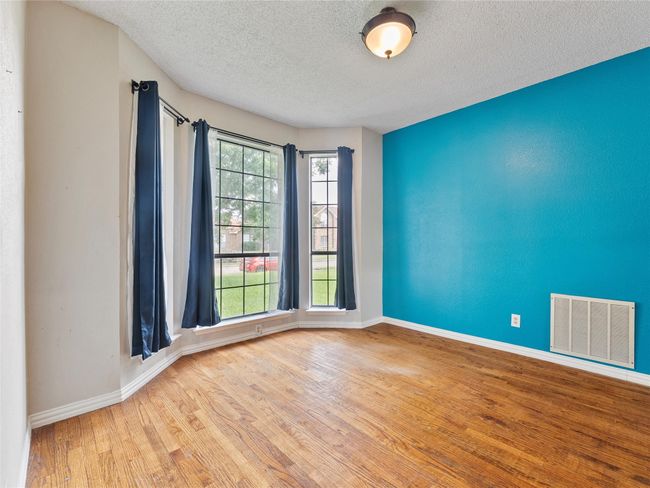 Spare room featuring wood finished floors and a textured ceiling | Image 7
