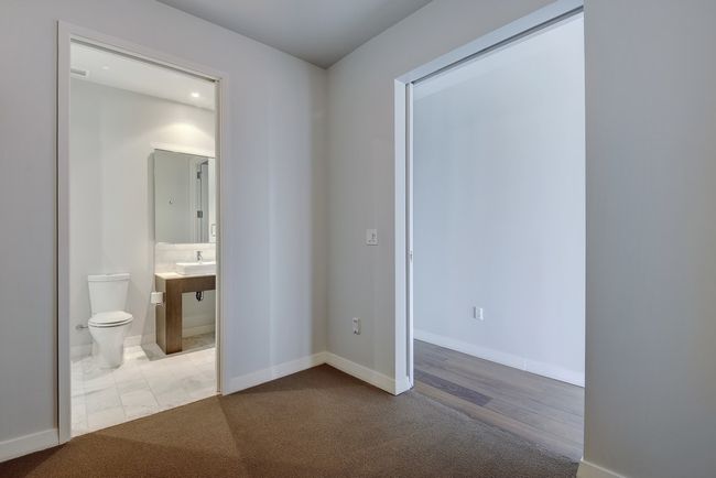 Unfurnished bedroom with baseboards, ensuite bath, and carpet flooring | Image 17
