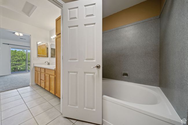Bathroom featuring tile patterned flooring, vanity, and a tub | Image 19