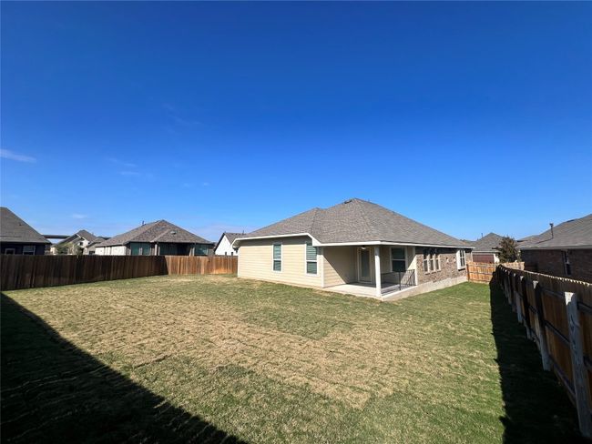 Rear view of house featuring a patio, a fenced backyard, and roof with shingles | Image 36