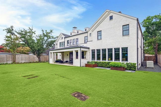 This well-maintained backyard features a covered patio area, ideal for outdoor activities and entertaining. The property is fenced and surrounded by mature trees, providing privacy and a serene atmosphere. | Image 34