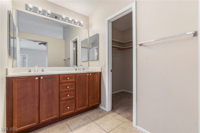 Full bathroom with double vanity, tile patterned flooring, and a walk in closet | Image 12