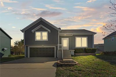 View of front of property featuring a lawn and a garage | Image 1