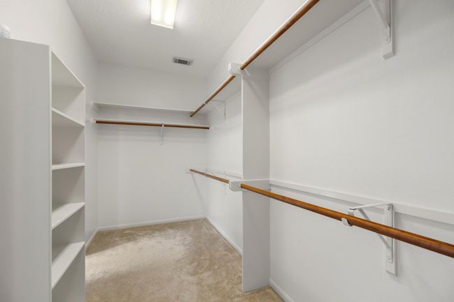 The primary walk-in closet offers built-in shelving and plenty of hanging space to keep everything organized and within reach. | Image 21