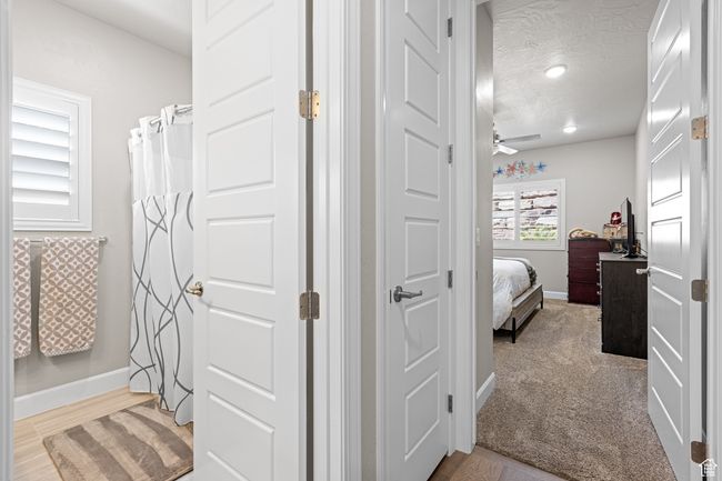 Full bathroom with ceiling fan, connected bathroom, a textured ceiling, and wood finished floors | Image 25