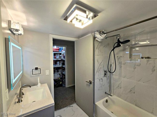 Full bathroom with marble finish floor, vanity, a walk in closet, and shower combination | Image 34