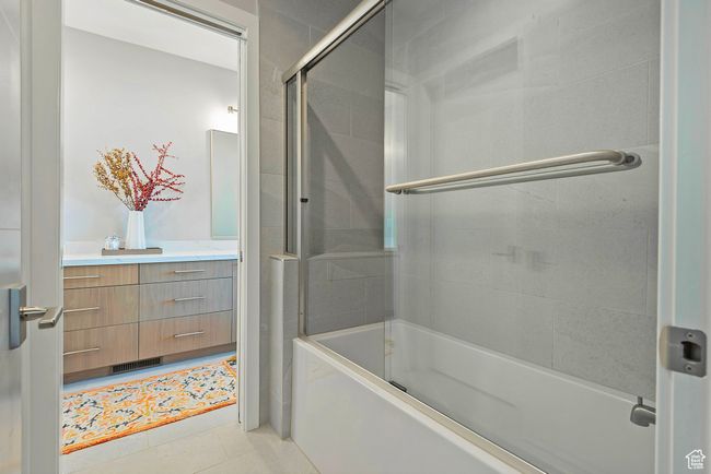 Full bathroom with visible vents, vanity, tile patterned flooring, and shower / bath combination with glass door | Image 26