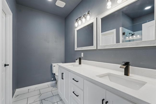 Full bathroom featuring tile finish floor, a stall shower, toilet, and a sink | Image 14