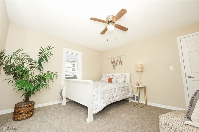 Bedroom featuring light carpet, a ceiling fan, and baseboards | Image 24