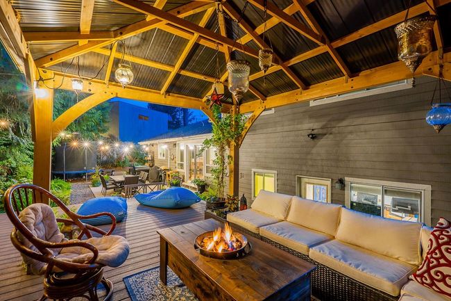 View of patio with an outdoor living space with a fire pit, a trampoline, a gazebo, and a deck | Image 26
