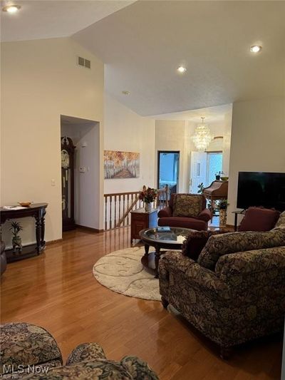 Living room with high vaulted ceiling, a chandelier, and hardwood / wood-style flooring | Image 3