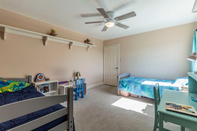 Carpeted bedroom with ceiling fan and baseboards | Image 23