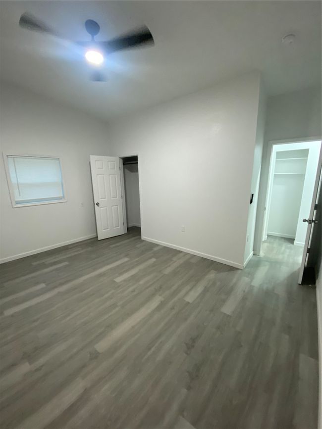 Unfurnished bedroom featuring baseboards, dark wood-style floors, and ceiling fan | Image 8