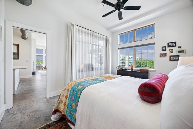 Bedroom featuring finished concrete flooring and ceiling fan | Image 14