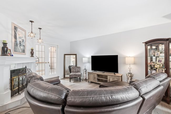 Living room with french doors, light wood-type flooring, and a tile fireplace | Image 18