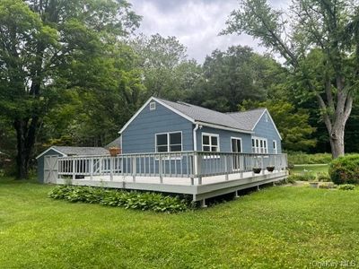 Rear view of property with a wooden deck, a yard, and a shed | Image 3