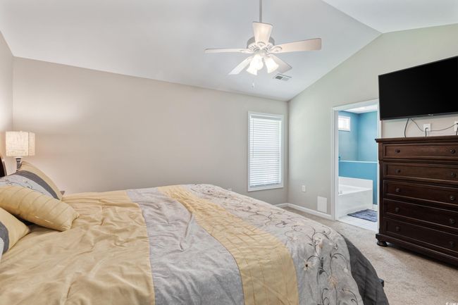 Bedroom featuring vaulted ceiling, carpet, ceiling fan, and connected bathroom | Image 20