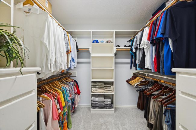 Expansive primary closet with ample shelving and drawers for all your storage needs. | Image 16