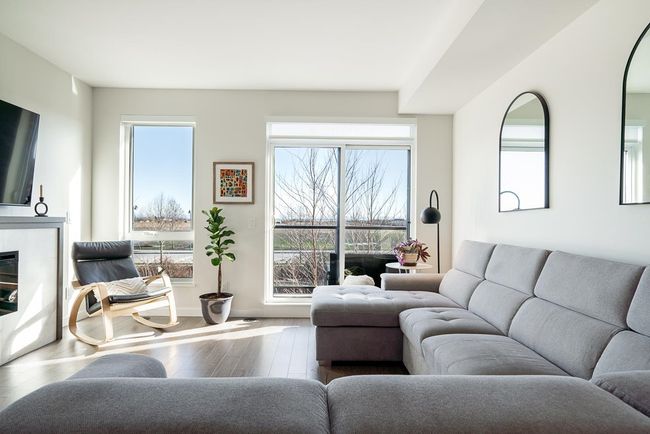 Living room with a glass covered fireplace and wood finished floors | Image 15