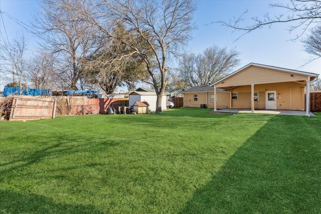 View of yard with an outbuilding, a storage unit, a fenced backyard, and a patio area | Image 22