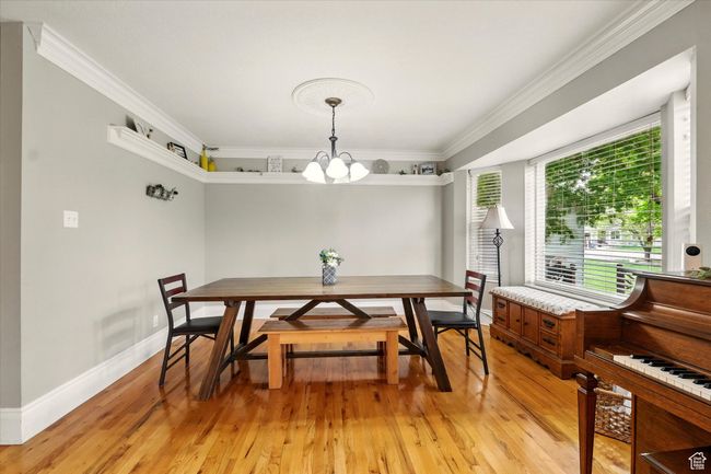 Dining room with a chandelier, light wood-style flooring, and crown molding | Image 43