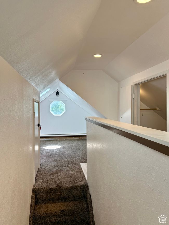 Stairs featuring carpet floors, vaulted ceiling, recessed lighting, and a baseboard heating unit | Image 24
