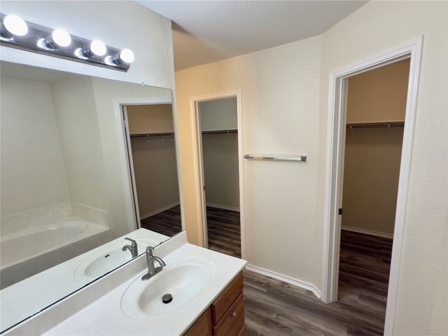 Full bathroom with vanity, a spacious closet, wood finished floors, and a bath | Image 25