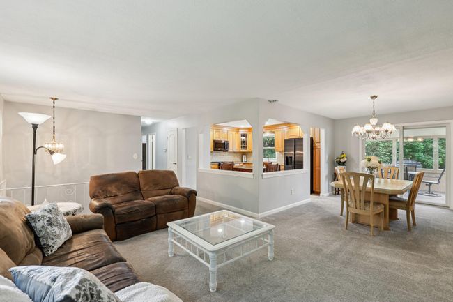 Living room featuring a chandelier and light colored carpet | Image 4