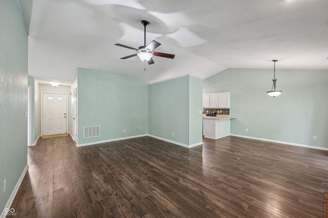 unfurnished living room featuring lofted ceiling, dark wood finished floors, and ceiling fan | Image 6