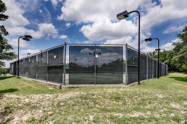 View of sport court featuring a lawn and fence | Image 10