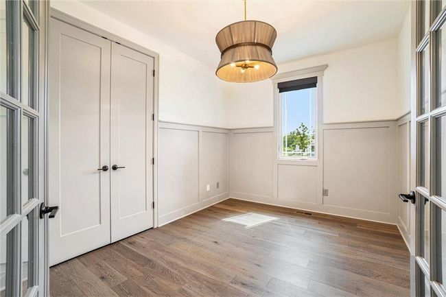 Unfurnished dining area with a decorative wall, wood finished floors, and a wainscoted wall | Image 37