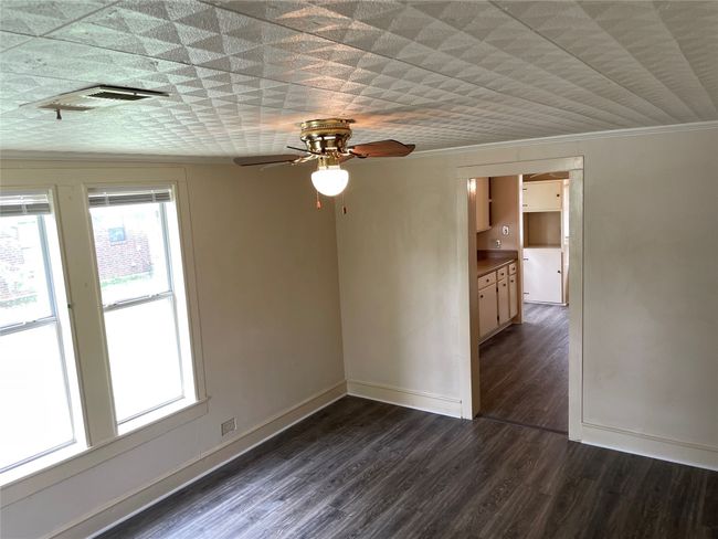 Living room featuring ceiling fan, baseboards, ornamental molding, and dark wood-style flooring | Image 4