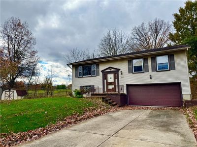 Split foyer home with a storage shed, a front lawn, and a garage | Image 2