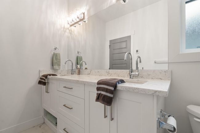 Bathroom featuring baseboards, toilet, double vanity, marble finish floor, and a sink | Image 20