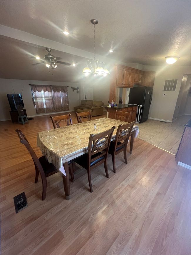 Dining room featuring light wood-type flooring, ceiling fan, and a textured ceiling | Image 11